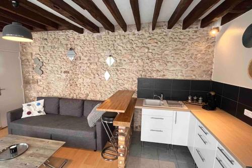 - une cuisine avec un canapé et une table dans une chambre dans l'établissement Duplex Cosy MyFontainebleau Hyper Centre, à Fontainebleau