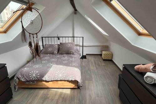 une chambre avec un lit dans un grenier dans l'établissement Duplex Cosy MyFontainebleau Hyper Centre, à Fontainebleau