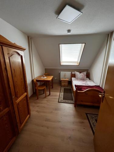 Zimmer mit einem Bett, einem Tisch und einem Fenster in der Unterkunft FeWo Osterzuschlag in Lähden