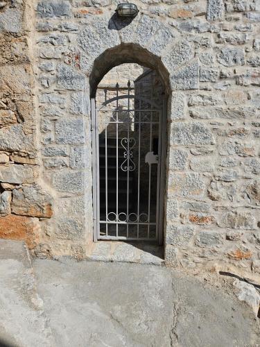 a gate on the side of a stone building at Rigas stone tower east Mani 1 in Mína