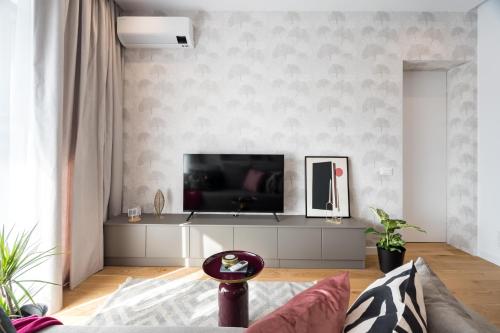 a living room with a flat screen tv on a wall at Cozy Business Area 1BR near Aviatiei in Bucharest