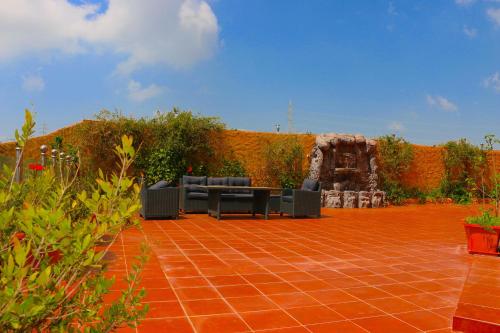 a patio with couches on a red brick ground at منتجع داري الهدا in Al Hada