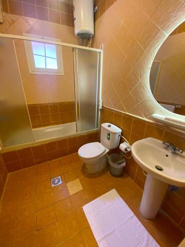 a bathroom with a toilet and a sink and a mirror at منتجع داري الهدا in Al Hada