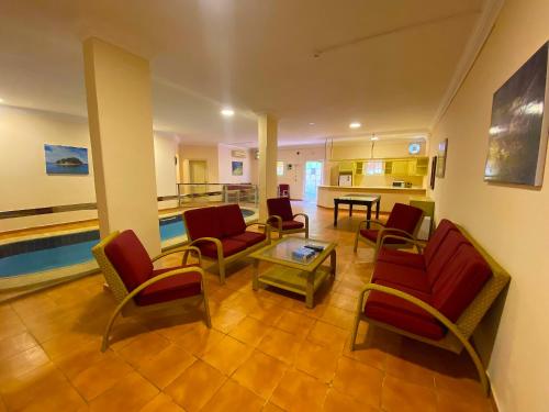 a living room with red chairs and a table at منتجع داري الهدا in Al Hada