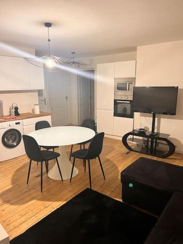 a living room with a table and chairs and a kitchen at F3 On Saint-Vit ! in Saint-Vit