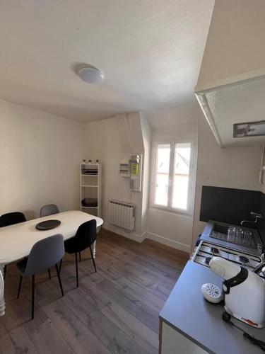 une cuisine avec une cuisinière et une table avec des chaises dans l'établissement L’appartement du Cher, à Chabris