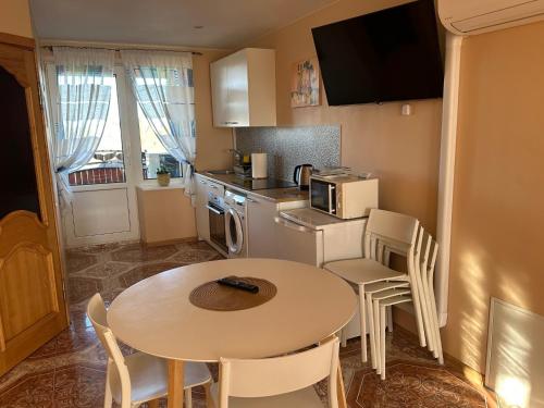 a small kitchen with a table and a table and chairs at Venta City Apartment in Venta