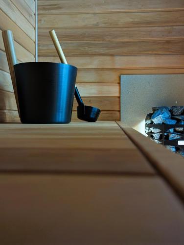 a black cup with two wooden sticks in it at Mere Apartment - Private Yard, Sauna and Pet Friendly in Pärnu