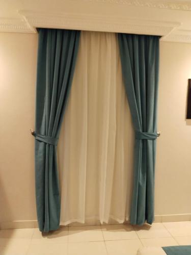 a pair of green curtains in a room at Etlalat Obhur in Jeddah