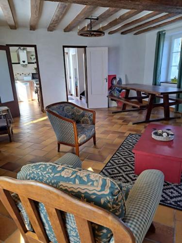 un salon avec des chaises et une table dans l'établissement Cottage chaleureux dans un ancien corps de ferme, à Marolles
