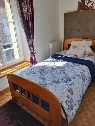 une chambre avec un lit avec une couette bleue et blanche dans l'établissement Cottage chaleureux dans un ancien corps de ferme, à Marolles