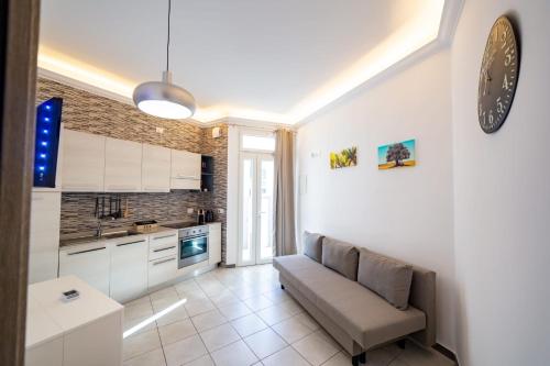 a living room with a couch and a kitchen at Loft 12/A in Modugno