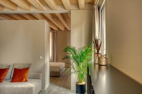 a living room with a couch and a table with plants at Do POMI Suite in Treviso