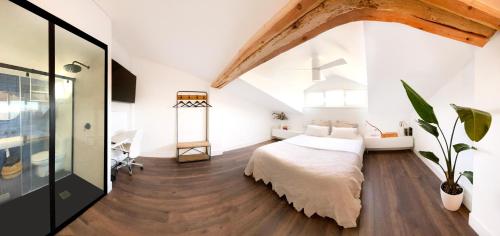 een slaapkamer met een groot bed en een houten vloer bij Luxury Pintoreria Atico in Vitoria-Gasteiz