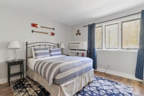 um quarto com uma cama e duas janelas em Modern Lake Geneva Condo with Year-Round Views em Lake Geneva