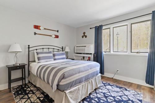 a bedroom with a bed and two windows at Modern Lake Geneva Condo with Year-Round Views in Lake Geneva