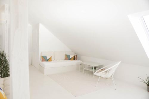 Cette chambre blanche dispose d'une table et d'une chaise. dans l'établissement Studio-Loft Siebengebirge Westerwald, à Erpel