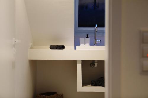 ein weißes Waschbecken mit einem TV darüber in der Unterkunft Studio-Loft Siebengebirge Westerwald in Erpel