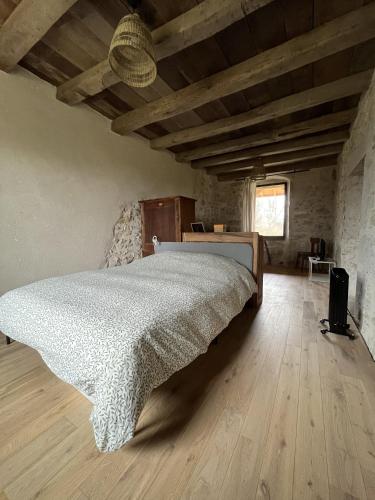 - une chambre avec un lit et du parquet dans l'établissement Appartement dans une vieille ferme bugiste, à Ceyzérieu