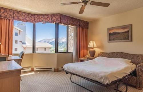 a bedroom with a bed and a large window at Studio 565 Perfect Location with Pool and Hot Tub in Crested Butte