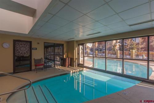 a large swimming pool with a large window in a building at Studio 565 Perfect Location with Pool and Hot Tub in Crested Butte