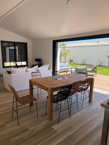 un salon avec une table et des chaises en bois dans l'établissement Villa - proche plages/commerces, au Bois-Plage-en-Ré