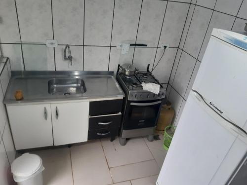 uma pequena cozinha com um fogão e um lavatório em Bairro tranquilo ha dez minutos de carro do centro da cidade em Curitiba