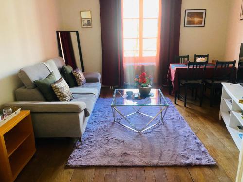 a living room with a couch and a glass table at Montreux appartement centre lac in Montreux