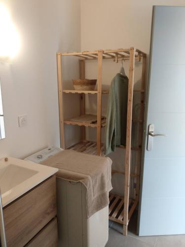 une petite cuisine avec évier et étagère. dans l'établissement A louer maison à Mimizan plage chez benoit, à Mimizan