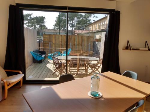 - une table avec une bouteille dans une chambre avec une terrasse dans l'établissement A louer maison à Mimizan plage chez benoit, à Mimizan
