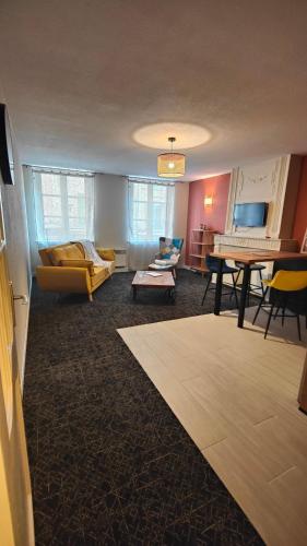 un salon avec un canapé et une table dans l'établissement Appartement de Charmes 2 Personnes Le Puy en Velay, au Puy-en-Velay