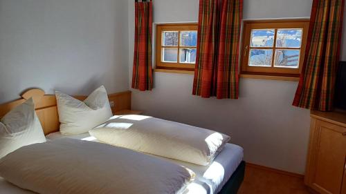 um quarto com 2 camas e 2 janelas em Viehhofgut em Bruck an der Grossglocknerstrasse