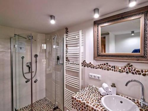 a bathroom with a sink and a shower and a mirror at Chic & Blick Die Ferienwohnung in Ebermannstadt