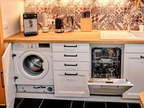 a kitchen with a washer and dryer under a counter at Chic & Blick Die Ferienwohnung in Ebermannstadt