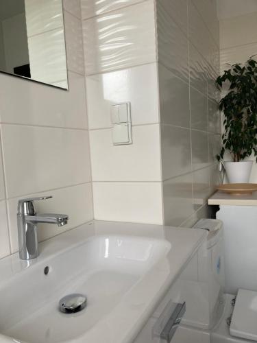 a white bathroom with a sink and a toilet at Apartament Argo in Gdańsk
