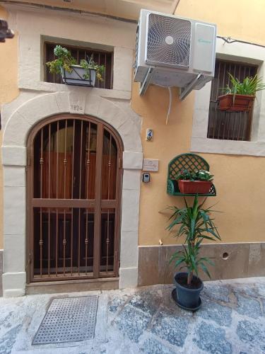 a building with a door and a fan and a plant at Cuore e Mare Ortigia in Syracuse