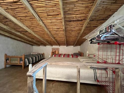 a bedroom with a large bed with a wooden ceiling at Mi casita de Los Andes in San Rafael