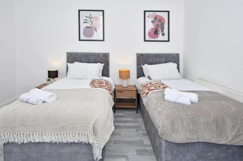 1 dormitorio con 2 camas y mesita de noche entre ellas en Myrtle House - By Sigma Stays, en Crewe