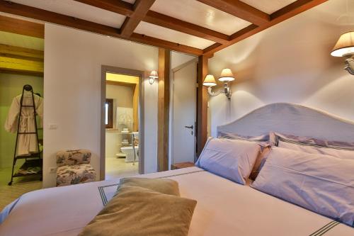 a bedroom with a white bed and a bathroom at Masseria D'Achille in Castel di Sangro