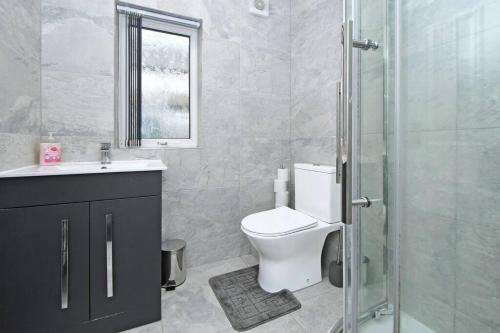 La salle de bains est pourvue de toilettes et d'une douche en verre. dans l'établissement Myrtle House - By Sigma Stays, à Crewe