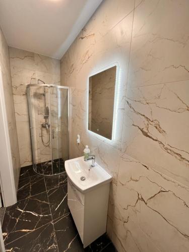 a white bathroom with a sink and a shower at The Old Townhouse in Krosno