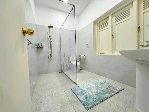 a bathroom with a shower and a toilet and a sink at Allure CMB by Allure Leisure in Nugegoda