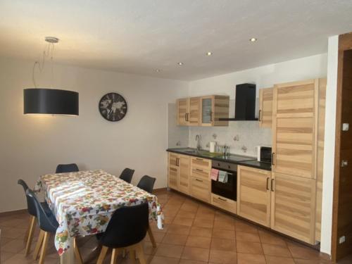 a kitchen with a table and some chairs and a table and a counter at APPARTAMENTO MORGEX in Morgex