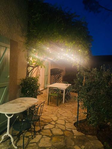 - une table et des chaises sur la terrasse la nuit dans l'établissement Magnifique villa avec jardin proche centre ville, climatisé, à Aix-en-Provence