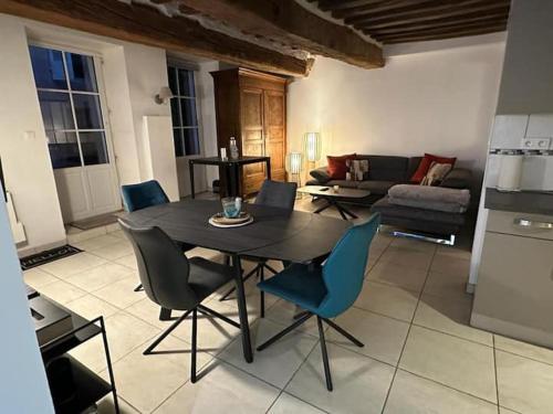 une cuisine et un salon avec une table et des chaises dans l'établissement appartement F3, à Chalon-sur-Saône