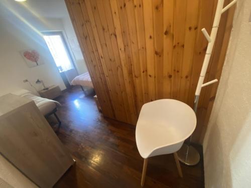 a white chair in a room with a wooden wall at APPARTAMENTO MORGEX in Morgex