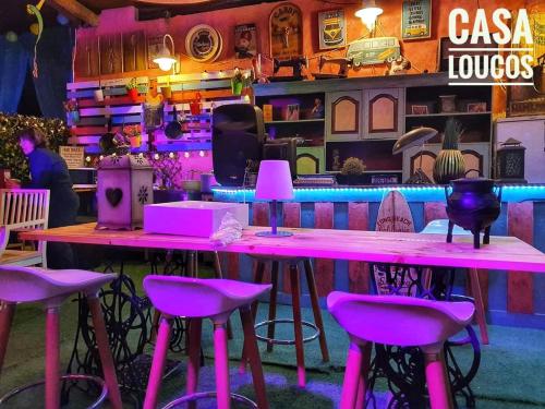 a bar with pink stools and a pink table at Bell Tent Lovers by Casa das Artes in Luz de Tavira