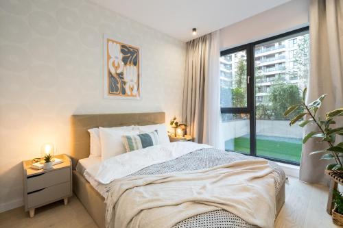 ブカレストにあるBOTANlQUE 1BR in Business Centreのベッドと大きな窓のある寝室