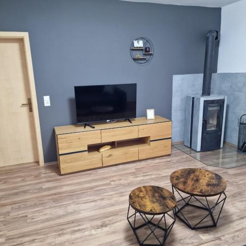 a living room with a tv and two stools at Apartment da Luiz Salvatore in Wurmlingen