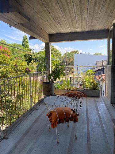 a porch with two metal chairs on a balcony at departamento A City Bell in City Bell
